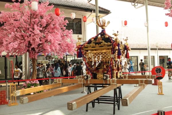 Omikoshi di antara dekorasi sakura dan pengunjung