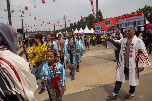 Peserta parade mengenakan busana tradisional di bawah lampion